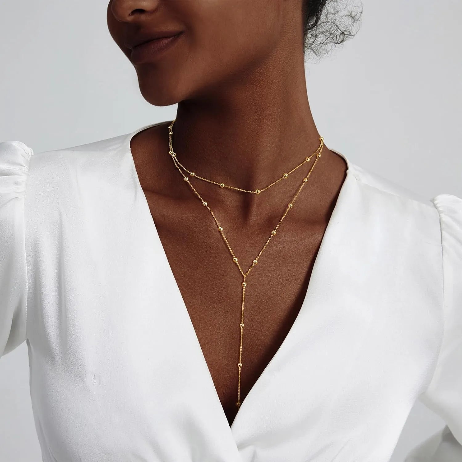 Rhinestone Y-lariat necklace worn with a V-neck dress for an elegant look